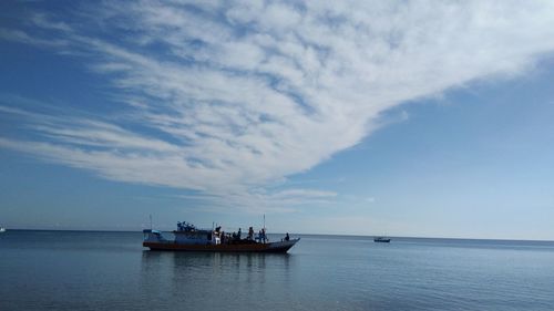 Fishing boat in sea against sky