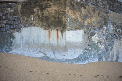 Close-up of weathered wall by sea