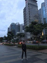 Rear view of man and woman on street against buildings