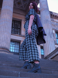 Low angle view of woman standing against building