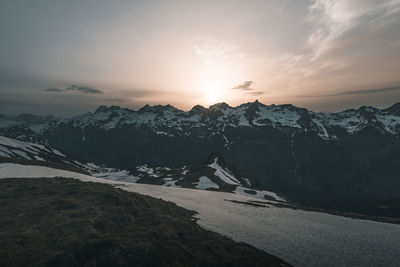 Scenic view of snowcapped mountains against sky during sunset