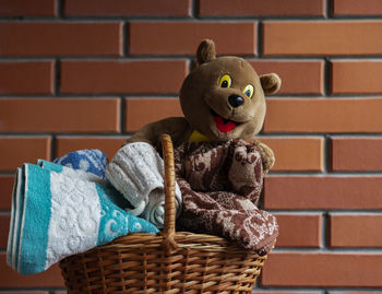 Close-up of stuffed toy against brick wall