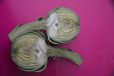 Close-up of sliced artichoke on pink background