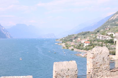 Scenic view of sea by town against sky