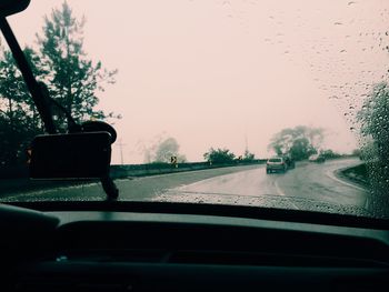 Road seen through car windshield during rainy season