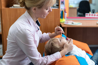 Midsection of doctor examining patient in hospital