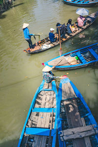High angle view of men on boat moored in river