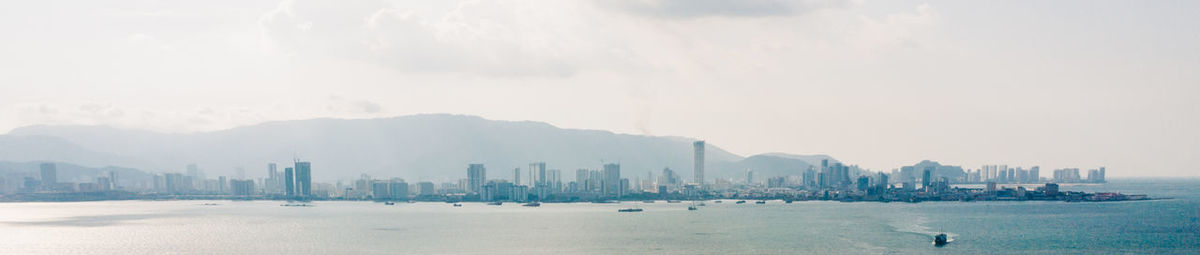 Panoramic view of sea and buildings against sky