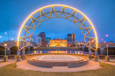 Illuminated ferris wheel in city at night