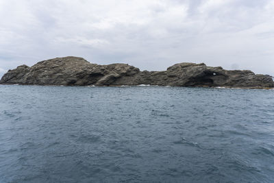 Rocks in sea against sky