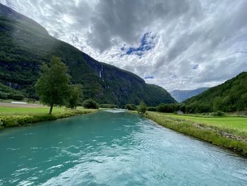 Scenic view of river amidst mountains against sky