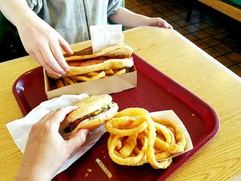 Cropped image of friends having fast food at table