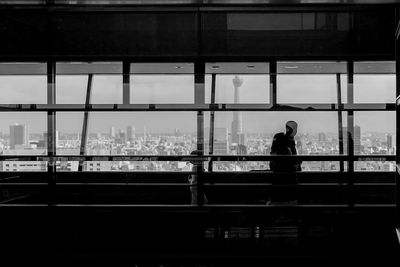 People seen through glass window walking in building