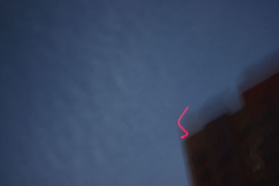 High section of red light against sky at night