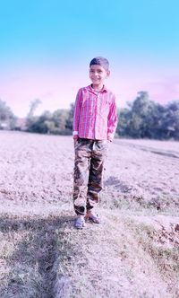 Portrait of boy standing on field