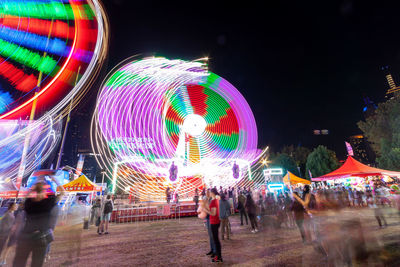 People in amusement park at night