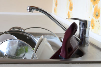 Utensils in kitchen sink at home