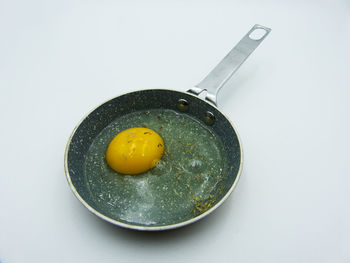 Close-up of lemon in plate against white background