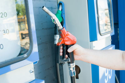 Cropped image of man holding fuel pump at gas station