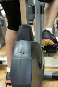 Low section of woman cycling in gym