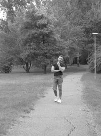 Full length portrait of young woman standing in park