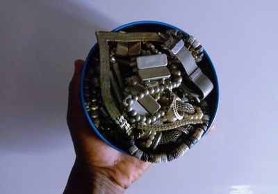 Close-up of hand holding metal against blue background