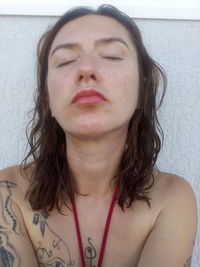 Portrait of beautiful woman against wall