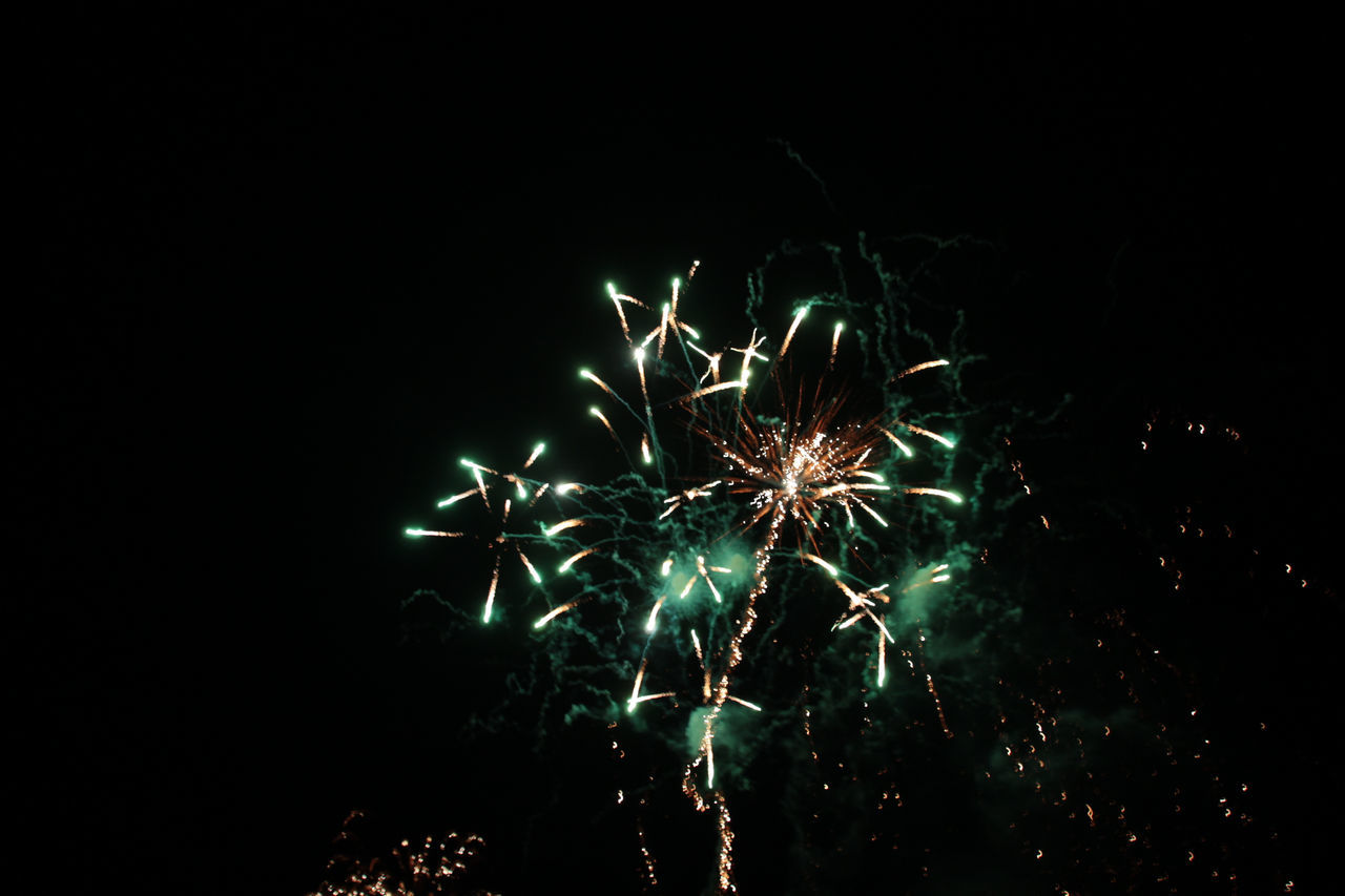 night, celebration, firework display, glowing, firework - man made object, exploding, long exposure, illuminated, event, blurred motion, dark, motion, arts culture and entertainment, no people, outdoors, firework, low angle view, multi colored, sky, clear sky, close-up