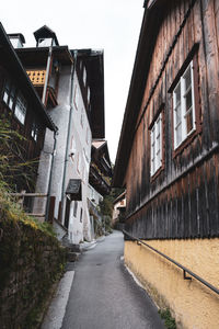 Empty road amidst buildings against sky