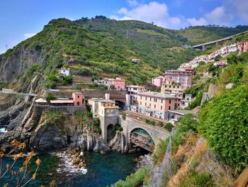 Arch bridge over river amidst buildings in city