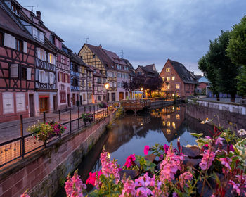 Canal amidst buildings in city against sky