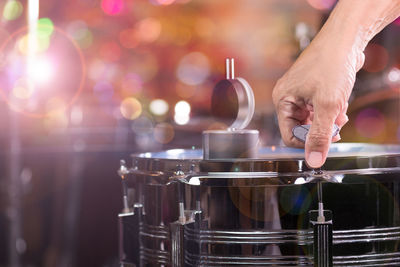 Close-up of cropped hand tightening drum at music concert