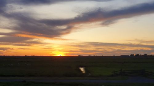 Scenic view of field against sky during sunset