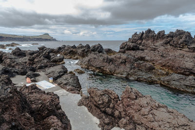 Rocks on beach against sky