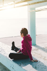 Side view of woman sitting on beach