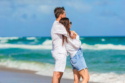 Side view of woman standing at beach