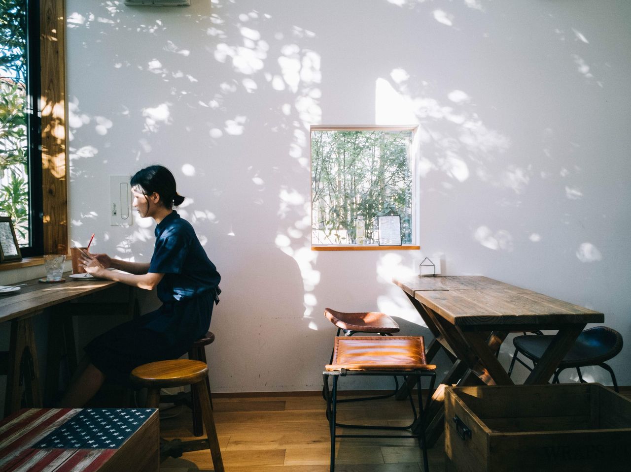 real people, table, one person, technology, young adult, seat, casual clothing, communication, wireless technology, chair, indoors, lifestyles, sitting, connection, full length, computer, adult, leisure activity, laptop, using laptop