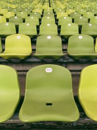 Full frame shot of empty green chairs at stadium