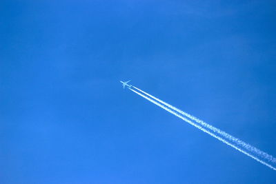 Low angle view of vapor trail against blue sky