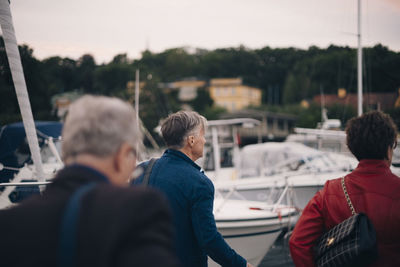 Rear view of senior women and man walking at harbor