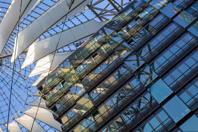 Low angle view of glass building against sky