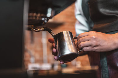 Midsection of man holding coffee cup