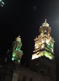 Low angle view of illuminated building against sky at night