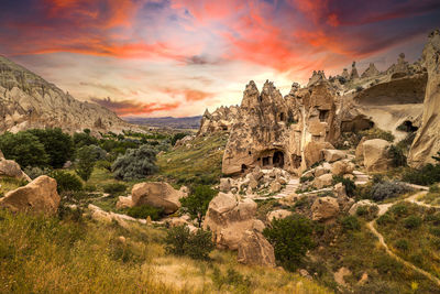 Rock formations on landscape against sky during sunset