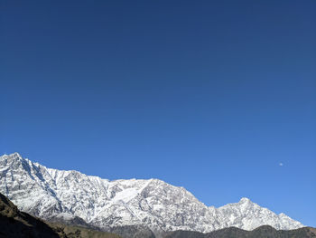 Snowcapped mountains against clear blue sky
