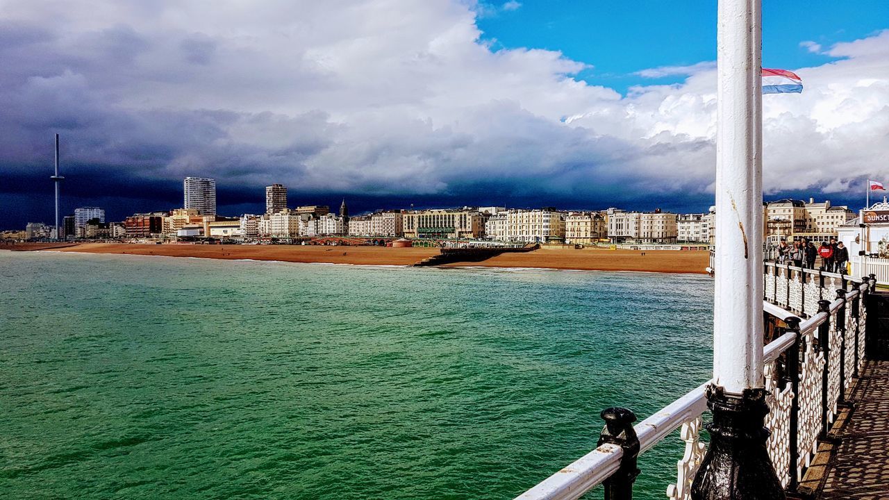 SCENIC VIEW OF SEA AGAINST BUILDINGS IN CITY