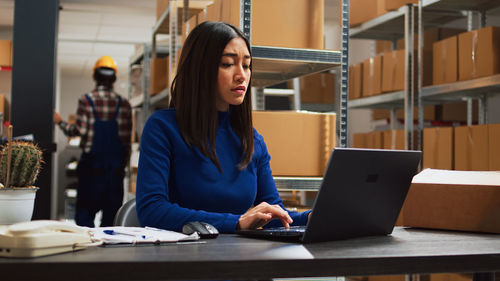 Young businesswoman using laptop at office