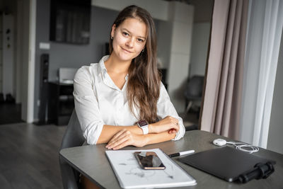Portrait of young woman using laptop at home