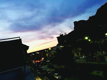 Illuminated city against sky at sunset