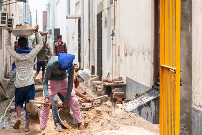 Rear view of people working at construction site